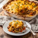 Hearty hobo casserole with ground beef, potatoes, carrots, and melted cheese.