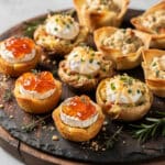 Oven baked mini brie bites and crispy potatoes on a rustic appetizer platter.