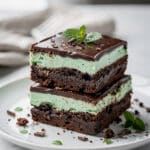 Fudgy mint chocolate brownies with creamy frosting and glossy ganache topping