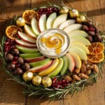 Festive New Years treat board with chocolates fruits nuts and creamy dip