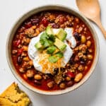 Hearty slow cooker turkey chili with beans cornbread and fresh garnishes