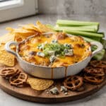 Ultimate Buffalo chicken dip delight with chips and celery for dipping.