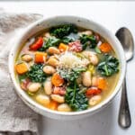 Creamy white bean kale soup recipe in a rustic bowl with parmesan