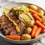 Beer braised corned beef and cabbage recipe with tender meat and vegetables.