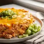 Creamy buffalo chicken dip with melted cheese and fresh celery carrot sticks