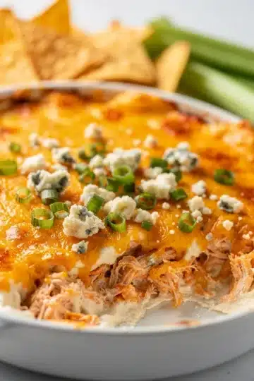 Creamy buffalo chicken dip with shredded chicken and melted cheese in ceramic dish