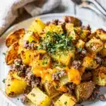 Cheesy corned beef hash with crispy potatoes and melted cheddar topped with eggs