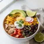 Creamy chicken tortilla soup with avocado and crispy tortilla strips.
