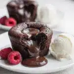 Chocolate lava cakes with a molten center, powdered sugar, and fresh raspberries.