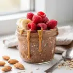 Creamy chocolate protein overnight oats topped with fresh fruit and peanut butter