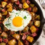 Corned beef hash skillet with crispy potatoes and a fried egg.