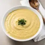 Creamy potato leek soup in a white bowl garnished with fresh chives.