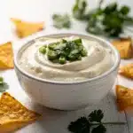 Creamy homemade queso blanco dip in a rustic ceramic bowl with tortilla chips.