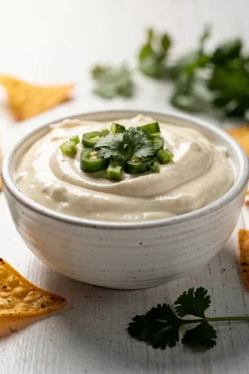 Creamy homemade queso blanco dip in a rustic ceramic bowl with tortilla chips.