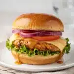 Juicy honey mustard chicken sandwich on toasted brioche with lettuce and tomato