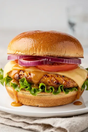 Juicy honey mustard chicken sandwich on toasted brioche with lettuce and tomato