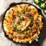 Creamy jalapeno popper dip with crispy bacon panko topping in cast iron skillet.