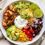 Spicy chicken burrito bowl recipe with avocado and crispy tortilla strips