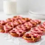 Strawberry chocolate covered pretzels with pink coating and heart sprinkles