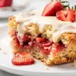 Golden brown strawberry lemon dump cake with almonds and vanilla ice cream.