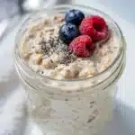 Creamy vanilla protein overnight oats topped with fresh berries and almond butter.
