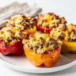 Moist chicken stuffed bell peppers with melted cheese in close up