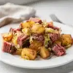 Crispy corned beef hash with cabbage and a fried egg in skillet