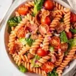 Creamy BLT pasta salad with bacon, tomatoes, lettuce, and glossy dressing