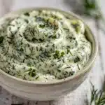 Creamy homemade herb mayonnaise with fresh dill and parsley in a bowl.