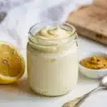 Creamy homemade mayonnaise recipe in a white bowl with olive oil drizzle