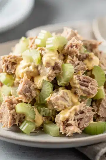 Creamy homemade mayonnaise in a clear glass jar on marble countertop