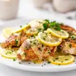 Creamy lemon chicken recipe with golden pieces in a glossy velvety sauce.