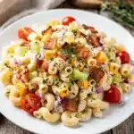 Creamy ranch pasta salad with bacon, cheddar, and fresh herbs in a bowl.