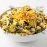 Creamy dill pickle pasta salad with rotini, cheddar, and fresh herbs.