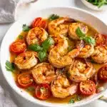 Garlic butter shrimp skillet recipe with tomatoes and fresh parsley garnish