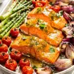 Close up of honey mustard glazed salmon with roasted asparagus and tomatoes