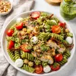 Creamy pesto chicken pasta salad with tomatoes chickpeas and mozzarella pearls