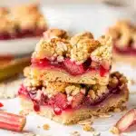 Rhubarb crumble bars feature a crispy oat topping and glossy fruit filling.