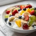 Creamy vanilla pudding fruit salad with vibrant berries and banana slices