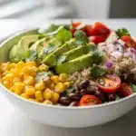 Colorful avocado corn quinoa salad bowl with fresh ingredients and creamy texture.