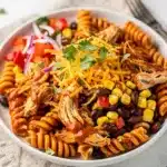 Creamy BBQ chicken pasta salad with corn, beans, and cheddar cheese.