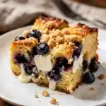 Make ahead blueberry cream cheese French toast bake with powdered sugar.