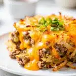 Cheesy crockpot sausage hashbrown casserole with golden crust and melted cheese.