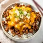 Cheesy Korean ground beef bowl with gooey cheese over rice and green onions
