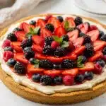 Classic berry cheesecake fruit pizza slice with fresh fruit and cream cheese