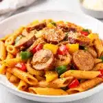 Creamy Cajun sausage pasta with penne in a glossy vibrant sauce.