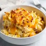 Creamy crockpot cheesy hashbrown casserole with melted cheddar and cornflake crust.