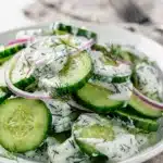 Creamy cucumber dill salad with yogurt dressing in a white bowl