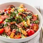 Creamy Italian pasta salad with pepperoni olives and artichokes in glossy dressing