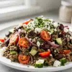 Creamy Mediterranean lentil salad with feta olives and fresh vegetables in bowl